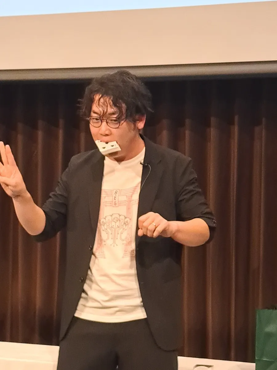 トランプの束をくわえて演じる名越