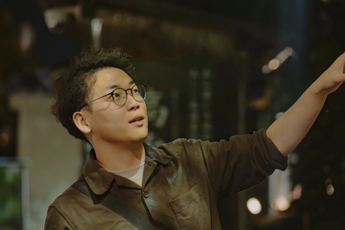 A guide speaking under a streetlight